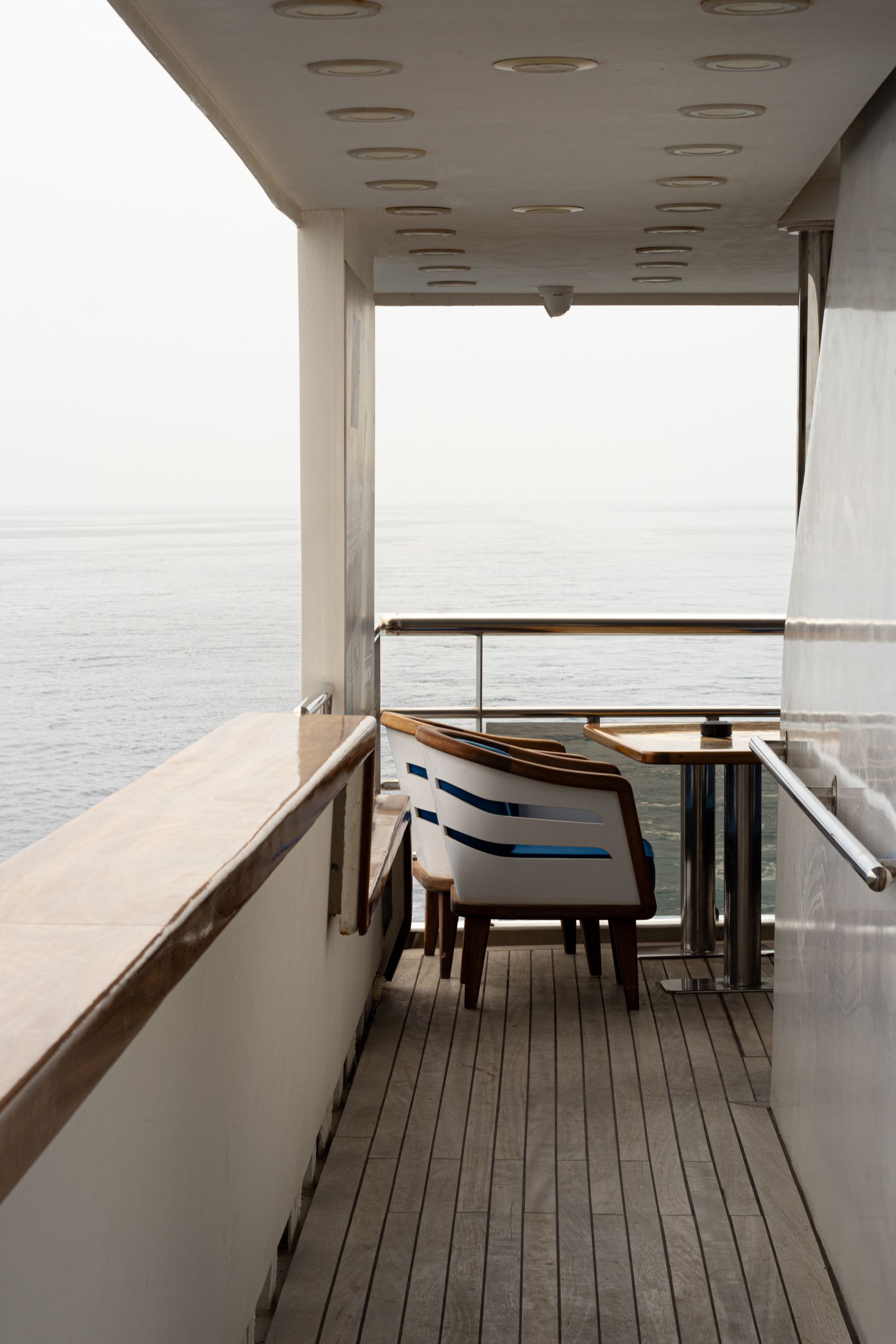 Shaded aft deck lounge with teak decking looking out to sea