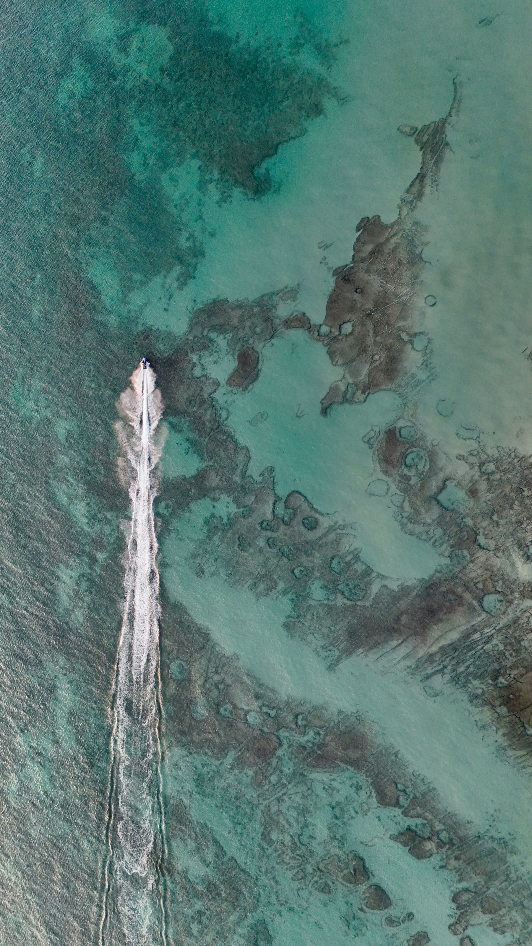 Boat cutting a wake across open ocean